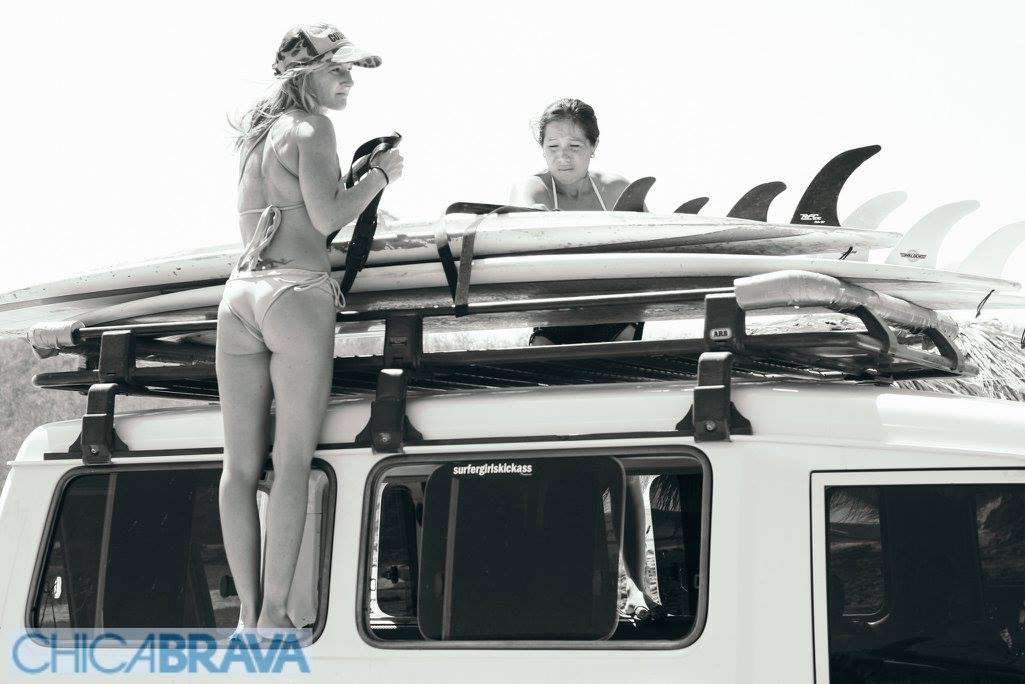Girls putting surf boards on top of car in San Juan Del Sur Nicaragua